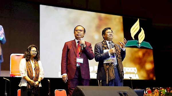 Adventist church's southern Asia-pacific region (SSD) president, Dr. Saw Samuel (in grey suit), with his translator SSD vice president Pastor Johnny Lubis, inspired Adventist members in west Indonesia with a message during a special musical concert organized by the local church in Jakarta. [frame capture by Joshua Sagala]